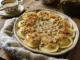 Pierożki z mięsem i sosem grzybowym ułożone w wieniec na półmisku